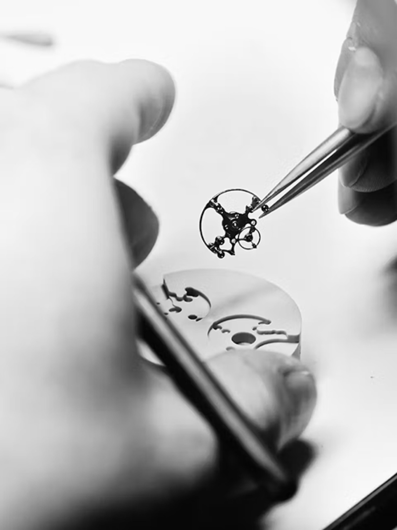 A watchmaker setting a movement component by hand